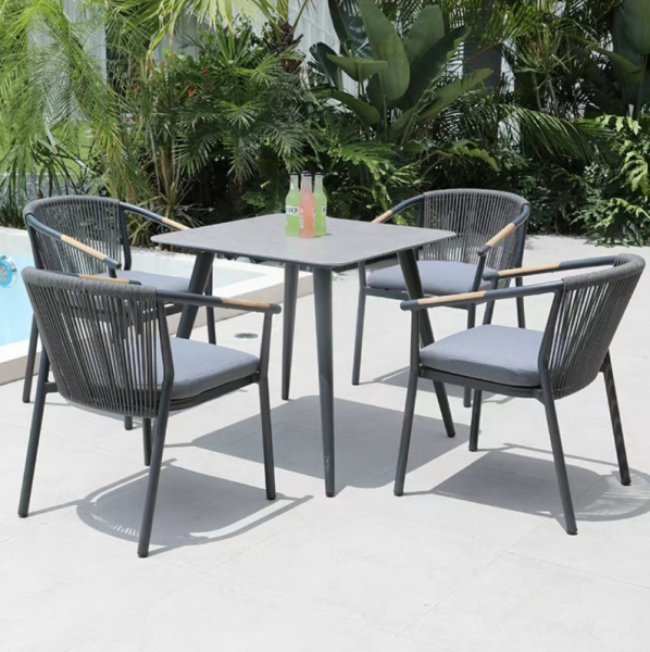 Achetez cet ensemble repas en aluminium et céramique, avec ses chaises en corde tressée et accoudoirs en teck, pour sublimer votre terrasse.